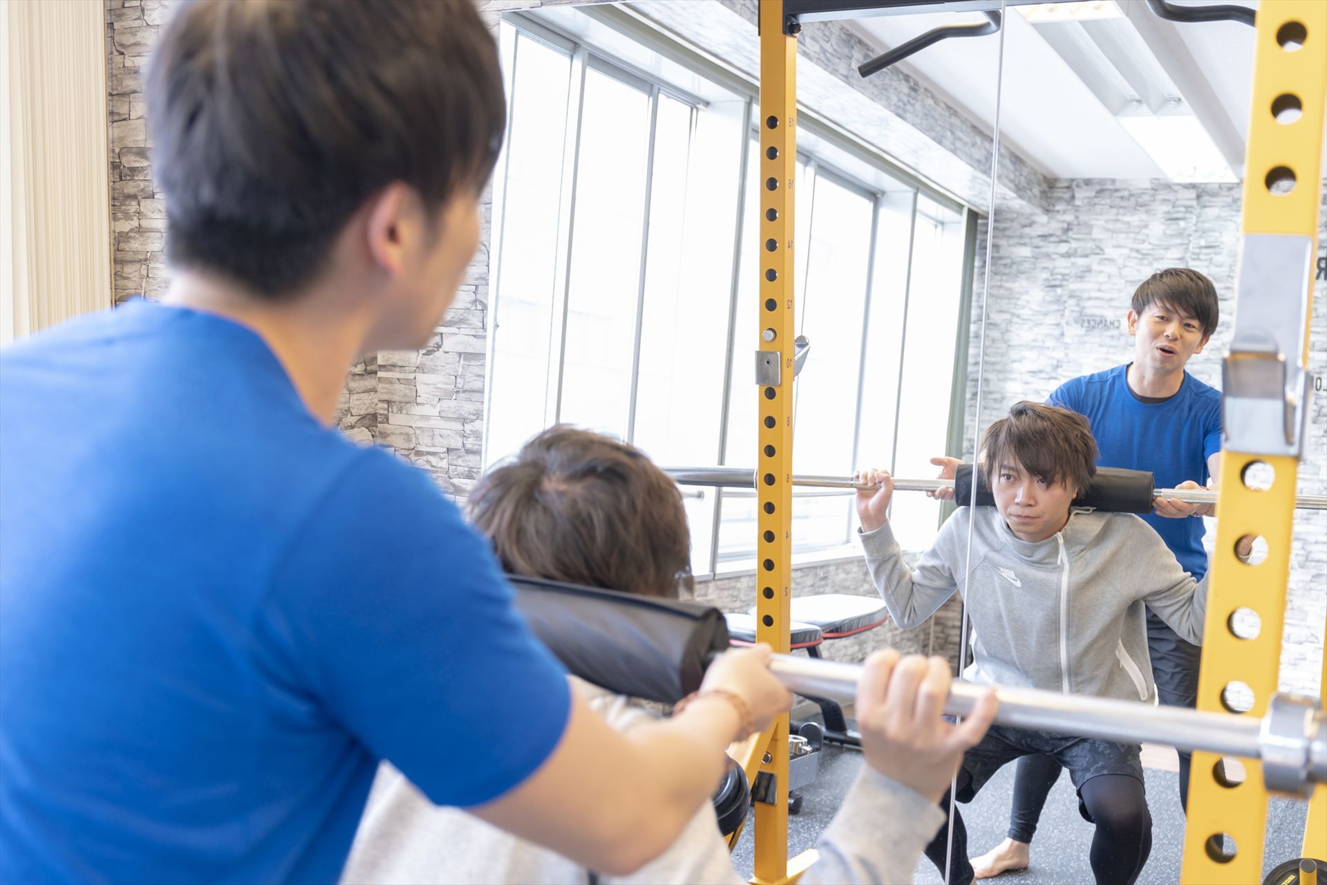 スクワットの指導を行うインストラクター